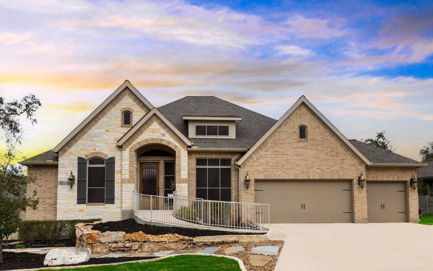 A new-construction stone and brick home with a three-car garage